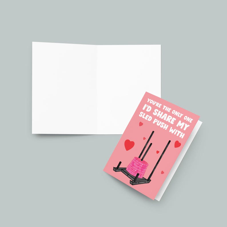 Pu&ograve; includere: Un biglietto rosa con un'illustrazione di una slitta per sollevamento pesi con il testo "You're the only one I'd share my sled push with".