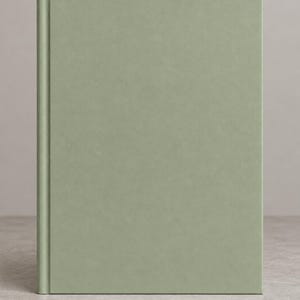 May include: A hardcover book with a solid, matte sage green cover. The front cover is plain and featureless, showcasing a smooth, uniform texture. The spine is clearly defined by a vertical indentation running along the left side.