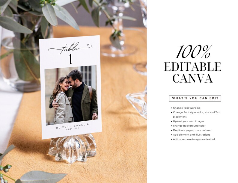 May include: A white card with a black script font that says "table 1" and a photo of a couple. The card is on a clear glass stand. The text "Oliver + Camelia 03.21.2023" is at the bottom of the card.