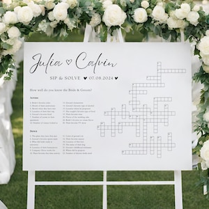 Könnte beinhalten: Ein weißes Hochzeitsschild mit einem Kreuzworträtsel, das die Gäste lösen können. Das Schild lautet "Julia & Calvin SIP & SOLVE 07.08.2024" und "How well do you know the Bride & Groom?"