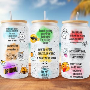 Op de afbeelding: Drie witte bekers met humoristische spreuken en cartoongezichten. De bekers hebben een bamboe deksel en een rietje. De spreuken zijn: "Wanneer ik naar het werk ga, verstop ik me altijd eerst, omdat een goede werknemer altijd moeilijk te vinden is. Mijn favoriete collega is koffie. Maandag zou optioneel moeten zijn."  "Ik ren niet weg van hard werken, ik ben te lui om te rennen. Hoe stress op het werk te vermijden: 1. Ga niet naar het werk. Als je me met mezelf ziet praten, Niet storen. Ik heb een vergadering met mijn innerlijke kind."  "Mijn baas heeft me gezegd om een ​​goede dag te hebben... Dus ben ik naar huis gegaan. Ik heb mijn symptomen gegoogled, het blijkt dat ik gewoon aan het werk ben. Sorry, ik kan morgen niet naar het werk gaan, ik heb mijn motivatie gebroken."
