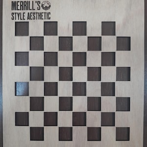May include: A wooden checkerboard stencil with alternating dark and light squares. The stencil has rounded corners and the text "MERRILL'S STYLE AESTHETIC" at the top.