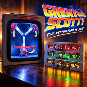 May include: A flux capacitor replica with a glowing blue Y-shaped light inside a grey housing, featuring red and yellow wiring. Next to it, a three-tier digital time display shows dates and times in red, green, and yellow LED lights with text.