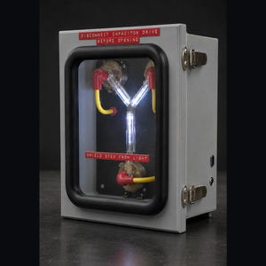 Flux Capacitor lit on a plain dark studio background, three-quarter view