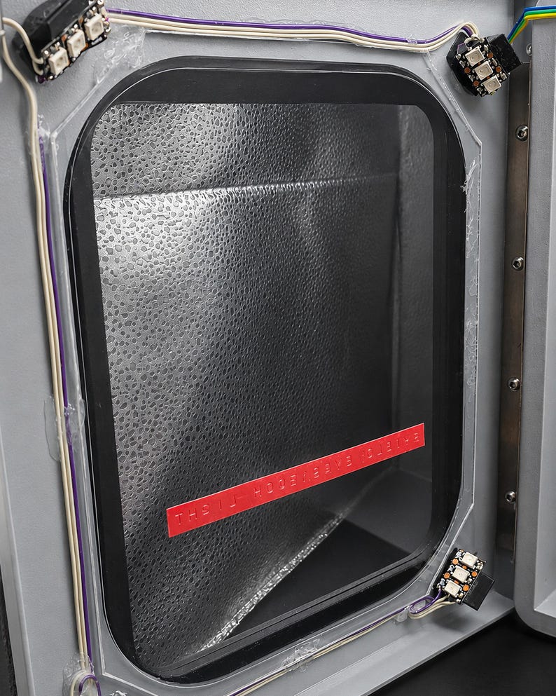 Hinged door open showing the addressable LED modules, wiring and gasket inside
