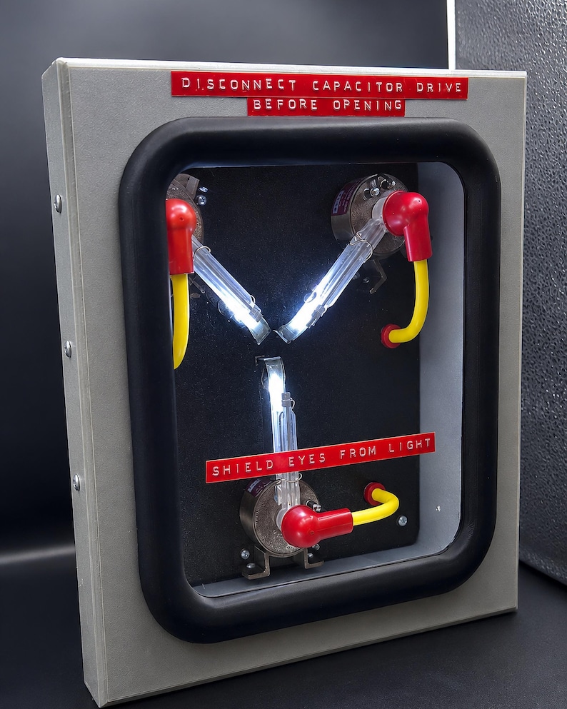 75% scale Flux Capacitor lit up, three glowing arms in a hinged metal case
