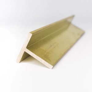 Puede incluir: Una moldura de esquina metálica de color dorado, en ángulo de 90 grados. La moldura tiene un perfil plano y rectangular con una superficie ligeramente texturizada. La pieza está diseñada para encajar en una esquina, proporcionando un acabado decorativo y protector.