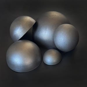 Peut inclure: Un groupe de cinq hémisphères gris métalliques de tailles différentes. Les hémisphères sont disposés en grappe, avec le plus grand hémisphère au centre.