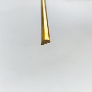 May include: A gold-colored, half-round, metal rod.