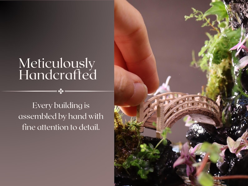 May include: A miniature wooden bridge with intricate details, surrounded by lush greenery and a small waterfall. The bridge is being carefully placed by a hand, highlighting the meticulous craftsmanship of this miniature garden.