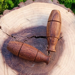 Könnte beinhalten: Drei Holzpfeifen, jede mit einem anderen Design, werden auf einer Holzscheibe präsentiert. Die Pfeifen sind braun und haben eine glatte, polierte Oberfläche.