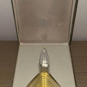 Könnte beinhalten: Eine Vintage-Flasche Guerlain Chamade Parfum in einer grünen Schachtel. Die Flasche ist aus klarem Glas mit einem herzförmigen Design und einem silbernen Verschluss. Die Schachtel ist mit weißem Satin ausgekleidet.