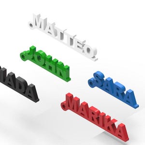 Può includere: Cinque targhette con nome personalizzate in diversi colori. I nomi sono "MATTEO", "JOHN", "GIADA", "SARA" e "MARIKA".