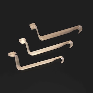 Può includere: Tre ganci in plastica beige con forma curva. I ganci sono impilati uno sopra l'altro.