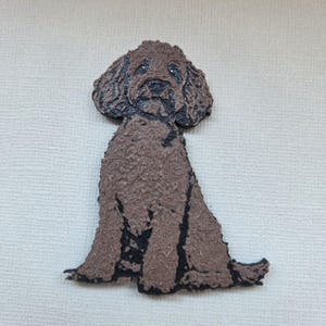May include: A brown dog figurine with a textured surface and black detailing. The dog is depicted in a seated position, with its head and body clearly visible. The figurine has a handcrafted look, suggesting it is a decorative item.