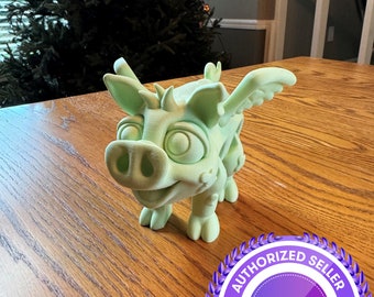 May include: A light green, cartoon-style dragon figurine with wings, standing on a wooden surface. The dragon has large eyes, a snout, and a smiling expression. A purple and white "Authorized Seller" seal is in the lower right corner.
