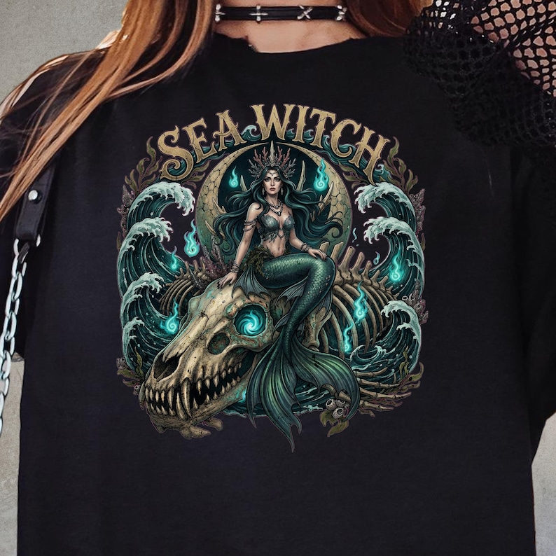 Dark gothic “Sea Witch” artwork featuring a haunting mermaid queen seated on a giant sea monster skull surrounded by crashing ocean waves, glowing blue spirit flames, coral details, and skeletal remains. The design combines occult ocean symbolism with fantasy horror aesthetics in deep teal, bone, and turquoise tones. Ideal for gothic fashion lovers, alternative streetwear, witchy apparel fans, and dark mermaid aesthetic clothing.