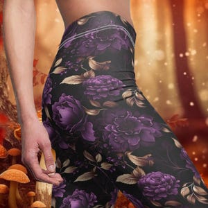 May include: Purple floral leggings with a black background. The leggings have a high waist and a fitted silhouette.