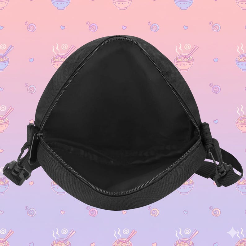 May include: Black messenger bag with an open zipper, revealing the interior. The bag has a rectangular shape with rounded corners and a black adjustable strap. The background features a repeating pattern of ramen bowls and hearts.
