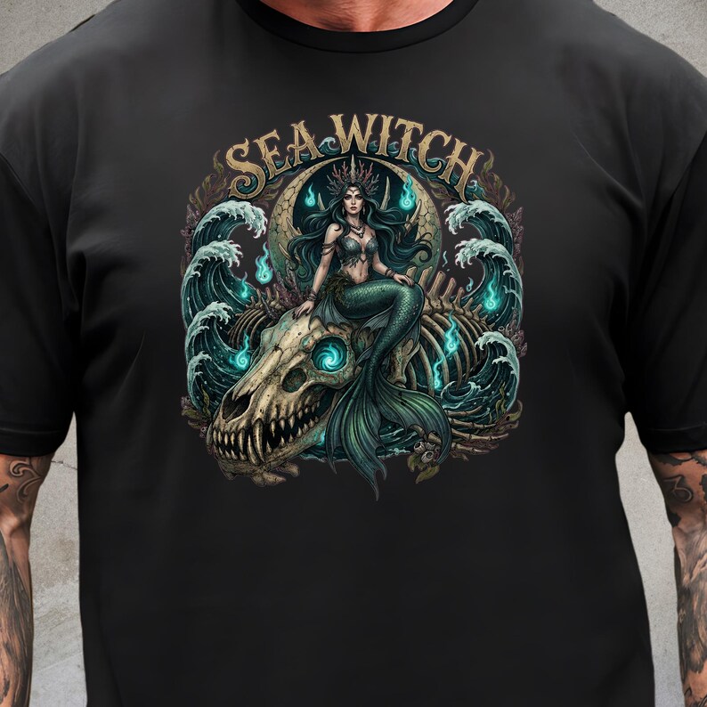 May include: Black t-shirt featuring a detailed graphic of a mermaid with a crown, sitting on a skull. The design includes the text "SEA WITCH" and elements of ocean waves and glowing blue accents.