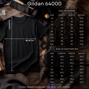 May include: Black Gildan 64000 t-shirt with size charts in inches and centimeters. The chart shows measurements for length, width, and sleeve for sizes XS to 5XL. The text "Product measurements may vary by up to 1.5' (3.8cm)." is at the bottom.