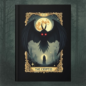 May include: Black journal featuring a tarot card design. The card depicts a black winged creature with red eyes against a full moon, with the text "THE CRYPTID" at the bottom. The card is framed in gold with the Roman numeral XVI at the top.
