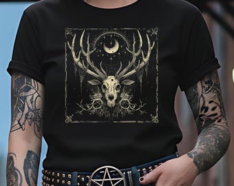 May include: Black t-shirt featuring a detailed graphic of a deer skull with large antlers, a crescent moon, and stars. The design is framed within a square and has a gothic aesthetic. The person is wearing a black belt with a silver pentagram buckle.