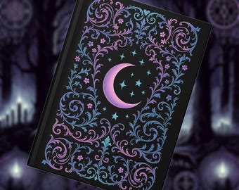 May include: Black journal with a crescent moon and star design. The cover features a floral and swirl pattern in shades of purple, blue, and pink. The journal has a dark background with a gothic theme.
