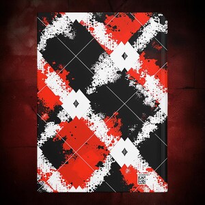 K&ouml;nnte beinhalten: Ein Hardcover-Notizbuch mit einem auff&auml;lligen geometrischen Design. Das Cover zeigt ein Muster aus schwarzen, roten und wei&szlig;en Rauten mit einem Spritzeffekt. Wei&szlig;e Rautenformen sind in den gr&ouml;&szlig;eren Rautenformen zentriert. Das Notizbuch hat einen dunklen Hintergrund.