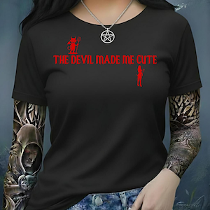 May include: Black t-shirt with the red text "THE DEVIL MADE ME CUTE". The shirt features a small red devil graphic and a silhouette of a woman. A silver necklace with a pentagram pendant is visible.