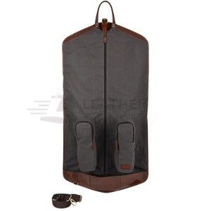 May include: A gray garment bag with brown leather trim and two zippered pockets. The bag has a shoulder strap and a zipper closure.