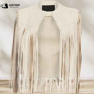 May include: A white leather jacket with fringe detailing. The jacket has a stand-up collar and a zipper closure. The fringe is on the sleeves and the bottom of the jacket.