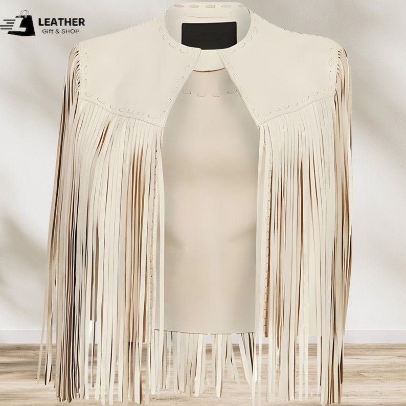 May include: A white leather jacket with fringe detailing. The jacket has a stand-up collar and a zipper closure. The fringe is on the sleeves and the bottom of the jacket.