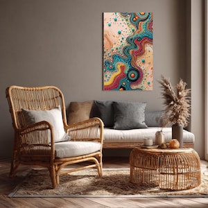 May include: An abstract wall art print with a colorful, dotted design in shades of teal, orange, yellow, and red. The artwork is displayed above a sofa and a rattan chair, creating a cozy living room setting.