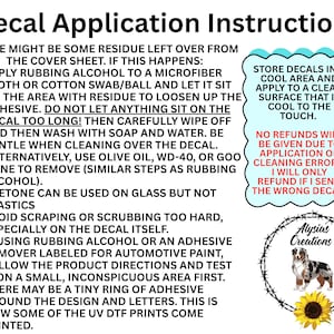 May include: A white informational sign titled Decal Application Instructions with black text detailing cleaning steps for adhesive residue. It includes a light blue scalloped box with storage tips and a circular logo featuring a dog and sunflower.