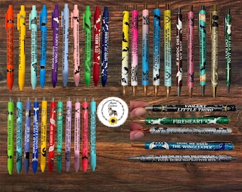 May include: A collection of colorful retractable pens featuring various printed quotes and graphic designs. The pens are displayed in rows and columns, showcasing diverse colors including red, yellow, blue, green, and purple, with some pens featuring glitter finishes and specific text like 'Violent Little Thing' and 'Fireheart'.