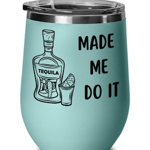 May include: A light blue stainless steel wine tumbler with a black graphic of a tequila bottle, shot glass, and lime wedge. The text "MADE ME DO IT" is printed on the tumbler.
