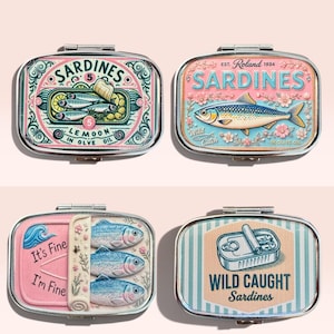 May include: Four rectangular metal tins featuring sardine-themed illustrations. One tin shows sardines with lemon, another displays a single fish with flowers, one features three fish with the text It's Fine I'm Fine, and one shows a tin with Wild Caught Sardines.