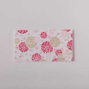 May include: A white envelope with a floral pattern. The pattern features red and gold flowers on a white background.