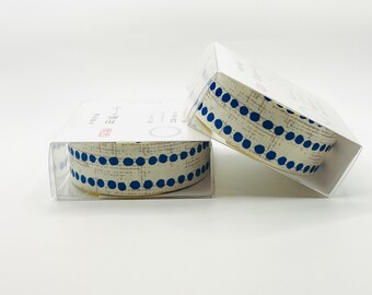 May include: Two rolls of washi tape with a white background and blue polka dots. The tape is in clear plastic packaging.
