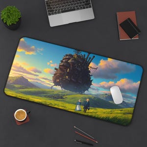 May include: A rectangular desk mat featuring a vibrant illustration of a large, complex mechanical castle structure looming over a grassy landscape with two figures standing in the foreground under a bright, colorful sunset sky.
