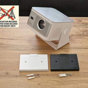Pode incluir: Um projetor branco e prateado com um suporte, acompanhado por uma placa de montagem branca e preta e parafusos. A imagem inclui um sinal que diz "NO PROJECTOR INCLUDED, NO TRIPOD STAND INCLUDED, CUSTOM MOUNT ONLY!"