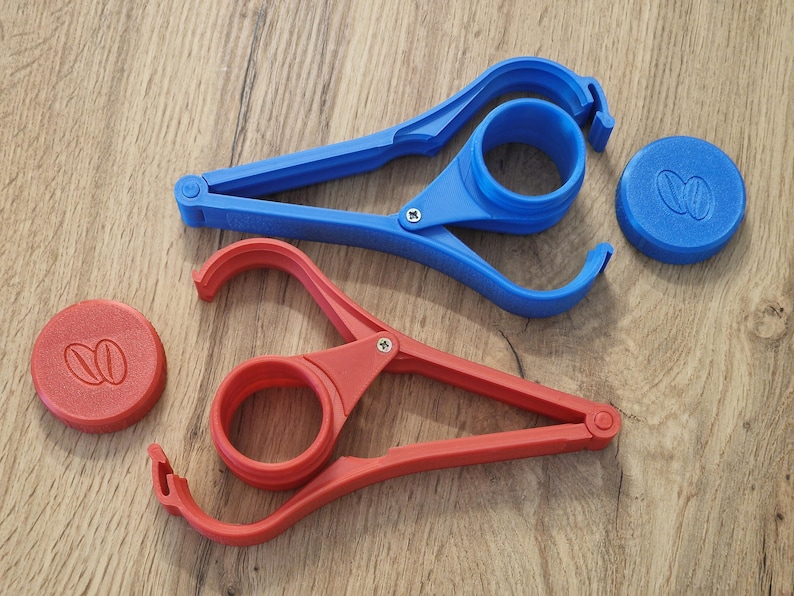 May include: Two plastic jar openers, one blue and one red, with a lid for each. The lids have a coffee bean design.