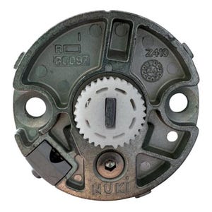 May include: A circular, metallic component featuring a central white gear and a rectangular keyway. The component has a grey finish with the text "R 80097" and "Z410" visible. The brand name "NUKI" is also present. The design includes multiple holes and a hexagonal screw.