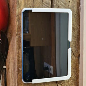 May include: A white tablet holder mounted on a wooden surface. The tablet is black and has a screen protector.
