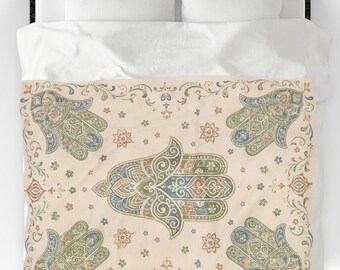 May include: A duvet cover featuring a repeating pattern of hamsa hand symbols in muted shades of blue, green, and orange on a cream background. The design includes intricate floral and scrollwork details surrounding the central hamsa motifs.