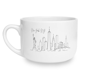 May include: A white ceramic mug featuring a black continuous line drawing of the New York City skyline, including the Statue of Liberty and the Brooklyn Bridge. The text New York, NY is written in a cursive script above the city silhouette.