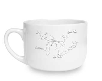 May include: A white ceramic mug featuring a black line art illustration of the Great Lakes. The design includes labels for Lake Superior, Lake Michigan, Lake Huron, Lake Erie, and Lake Ontario, with the text Great Lakes printed above the map.