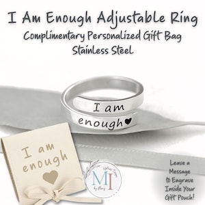 May include: A silver-colored, adjustable ring engraved with the words "I am enough" and a heart symbol. The ring is displayed with a small beige gift bag also inscribed with "I am enough". The text "I Am Enough Adjustable Ring" is at the top.