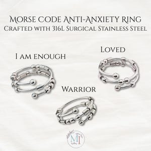 May include: Three silver-colored rings made of 316L surgical stainless steel, each featuring a multi-strand design with small metal beads and cylinders. The text reads: MORSE CODE ANTI-ANXIETY RING, CRAFTED WITH 316L SURGICAL STAINLESS STEEL, I AM ENOUGH, LOVED, and WARRIOR.